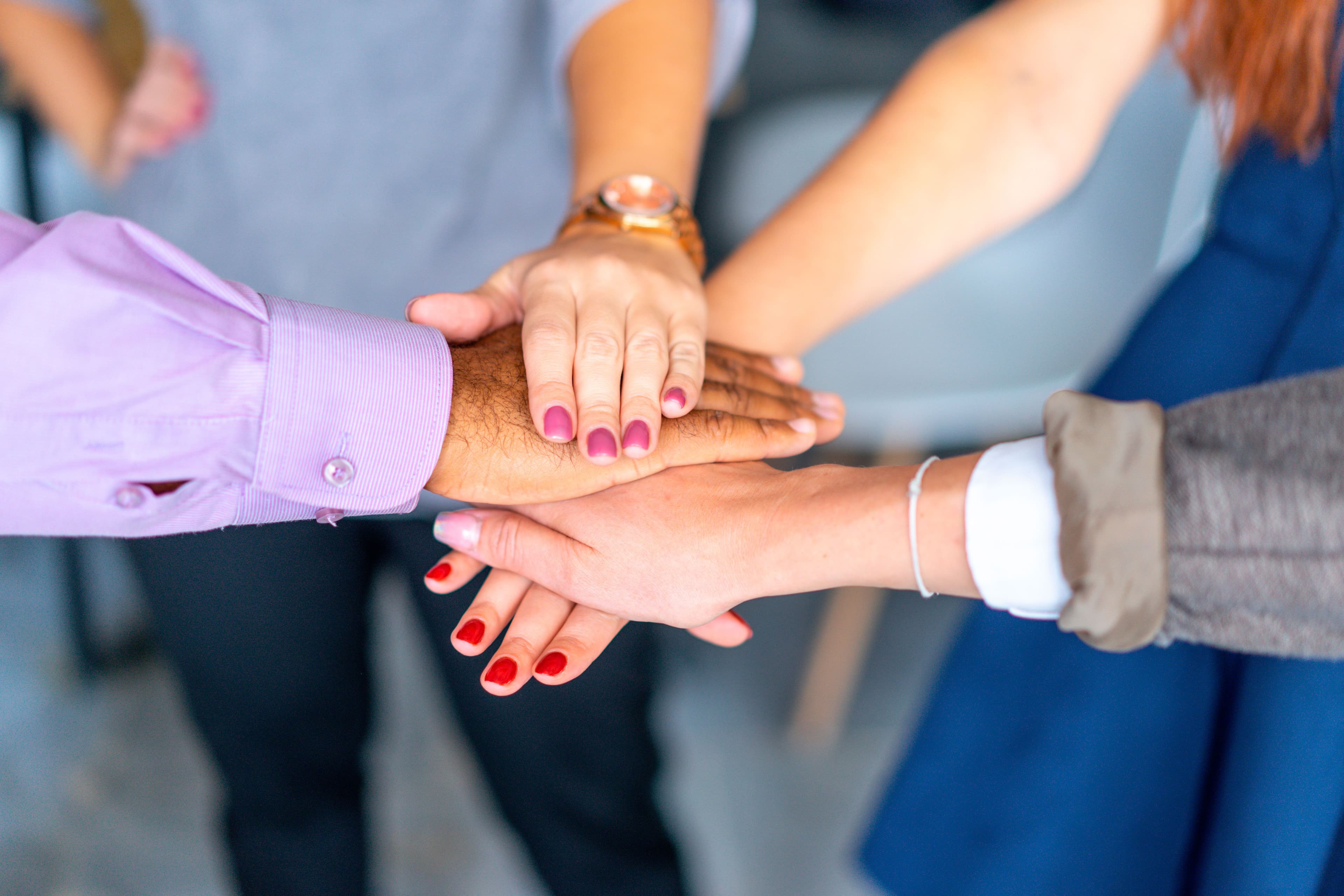 A group of people joining hands together